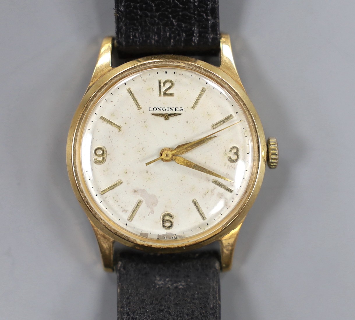 A gentleman's 1960's 9ct gold Longines manual wind wrist watch, with case back inscription, case diameter 33mm, on associated leather strap, gross weight 36.5 grams.